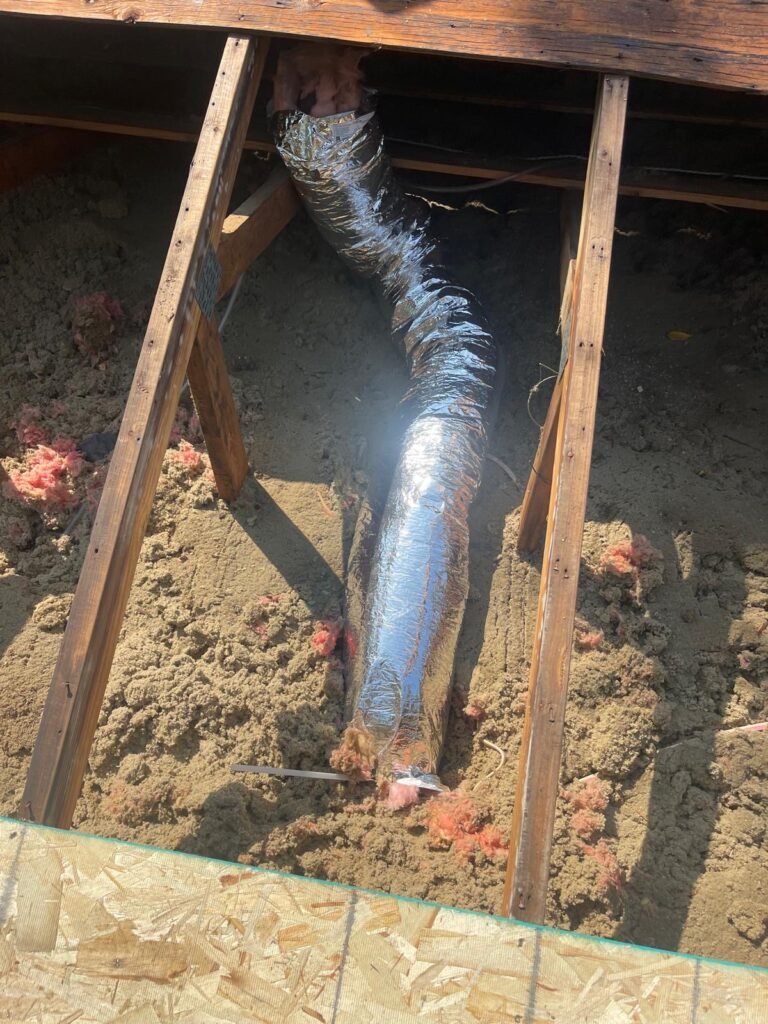 Roof bathroom vent surrounded by insulation